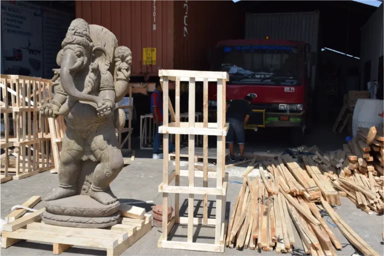 A seated elephant statue on a pallet.